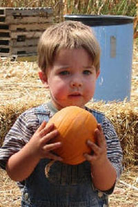 child with pumpkin